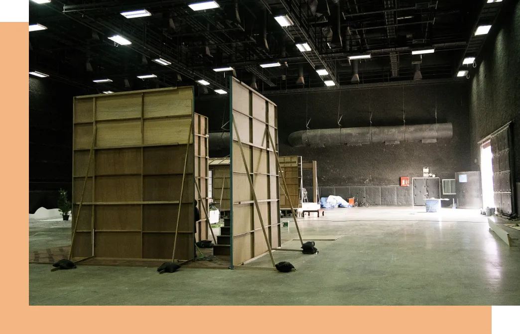 Un décor de théâtre rangé dans un vaste entrepôt.